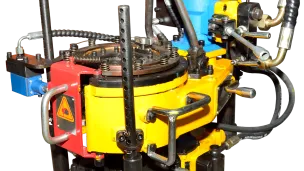 Industrial hydraulic machine with yellow, blue, and red components and gauges.