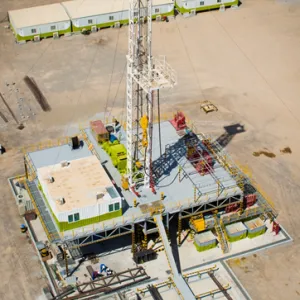 Aerial view of an oil drilling rig in a desert landscape.